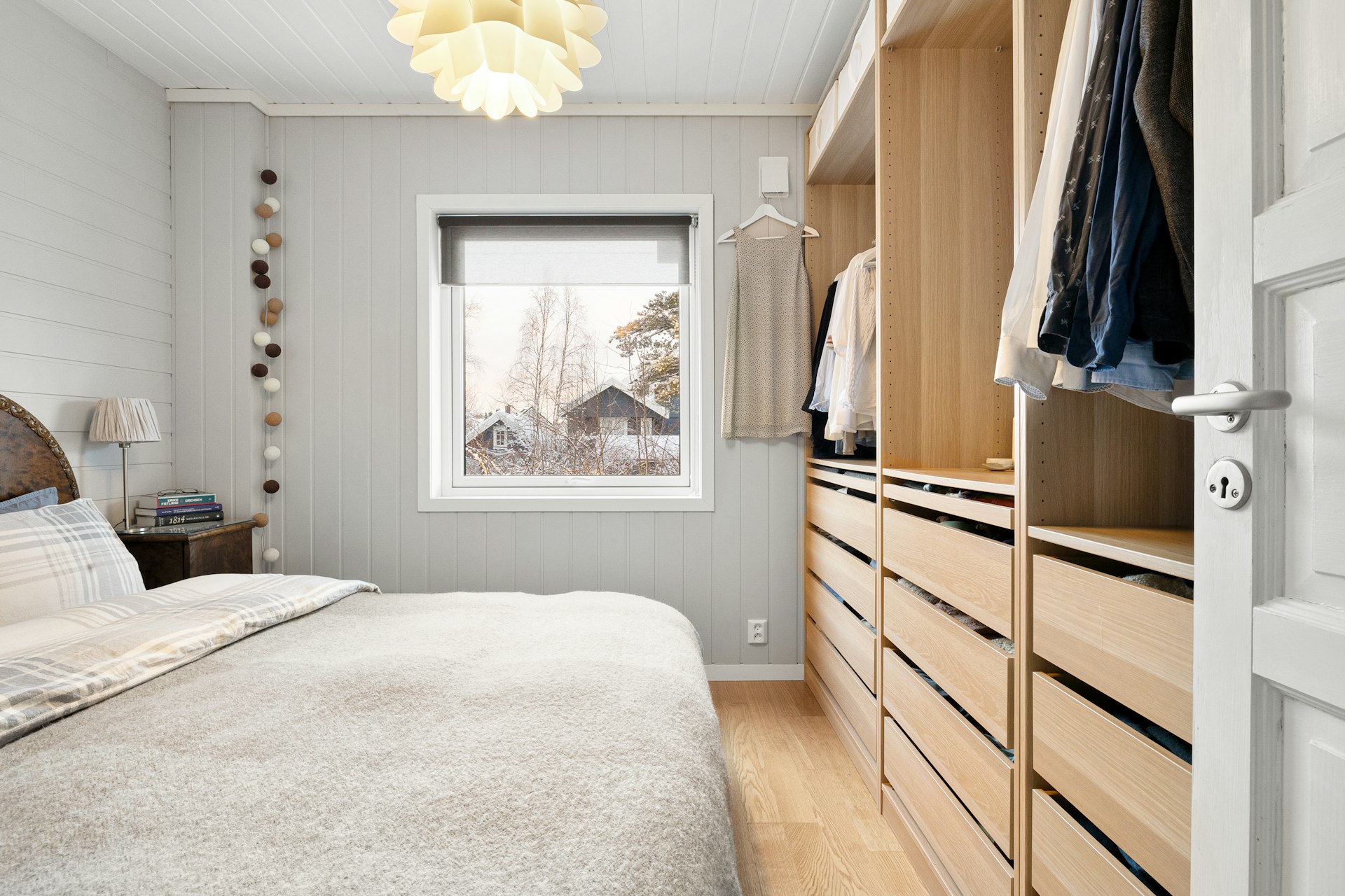 A bedroom with a bed, dresser, and a window